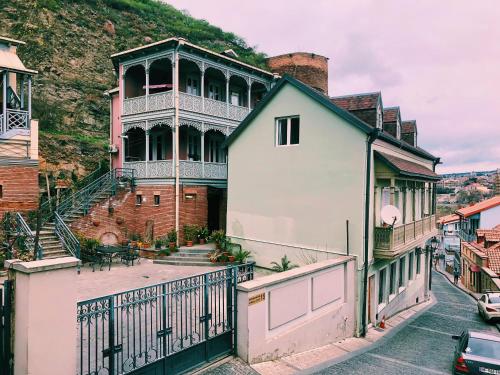 uma casa grande com uma varanda numa rua em Apartment Botanikuri 15 em Tbilisi