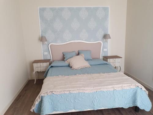 a bedroom with a large bed with a blue headboard at Romantic Home in Sirmione