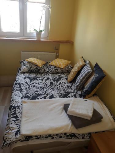 a bed with pillows on it in a room at Apartament Czwarte Piętro in Świecie