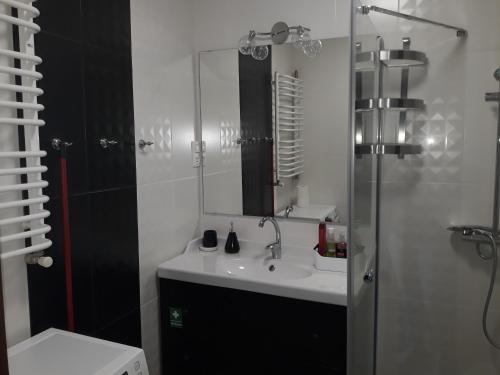 a white bathroom with a sink and a mirror at Apartament Czwarte Piętro in Świecie