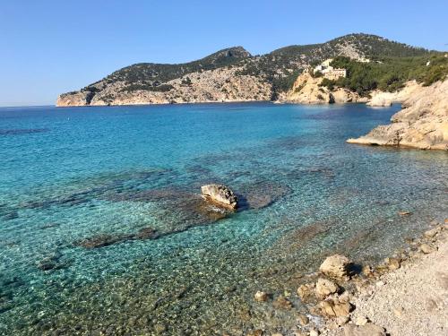 a beach with clear blue water and a mountain at Poolvilla Patricia - Camp de Mar in Andratx