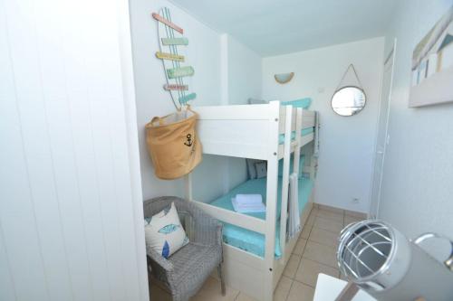 Camera piccola con letto a castello e sedia di APPT T3 Rêve d'Océan les pieds dans l'eau a Lacanau