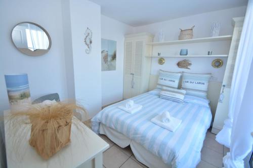 una camera da letto con un letto con asciugamani sopra di APPT T3 Rêve d'Océan les pieds dans l'eau a Lacanau