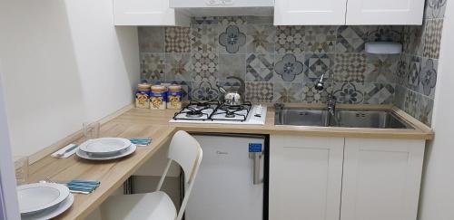 una piccola cucina con lavandino e piano cottura di Studio One a Napoli
