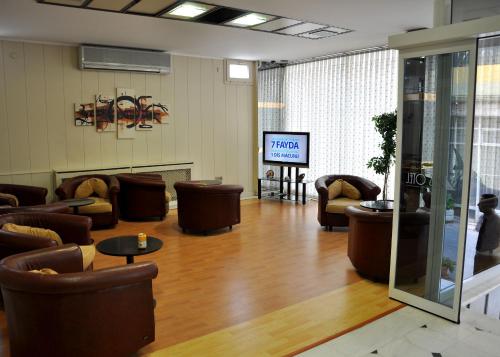 a lobby with couches and chairs and a television at Grand Reis Hotel in Istanbul