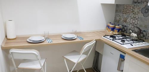 una cucina con bancone, 2 sedie e piano cottura di Studio One a Napoli