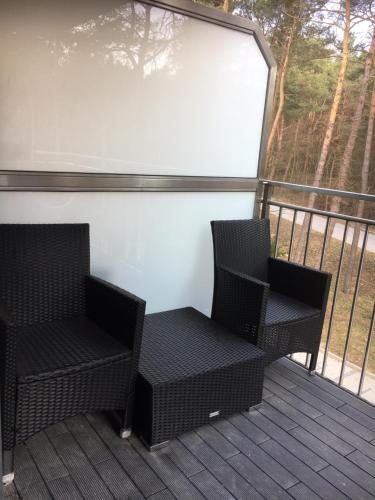 two chairs sitting on a deck with a screen at Family & Business Sauna Apartments No2 Leśny nad Zalewem Cedzyna - 2 Bedroom with Private Sauna, Bath with Hydromassage, Terrace, Parking, Catering Options in Kielce