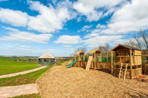 a wooden playground with a slide and a building at Four Winds,Kinsale Town,Exquisite holiday homes,sleeps 26 in Kinsale