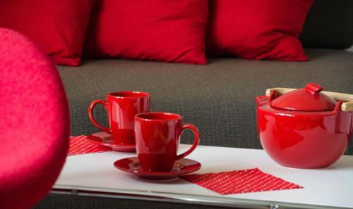 a table with red cups and saucers on it at Ferienwohnung Christine in Thale