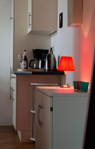 a small kitchen with a red lamp on a counter at Ferienwohnung Christine in Thale