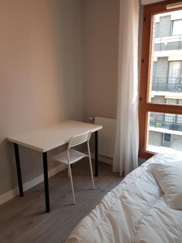 a table and a chair in a room with a bed at Appartement de 2 chambres au Centre de Cergy in Cergy