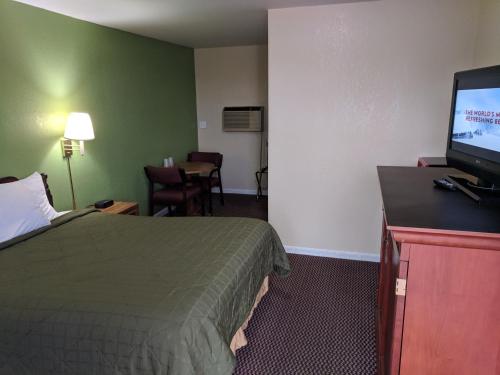 a hotel room with a bed and a flat screen tv at Benton Inn in Benton