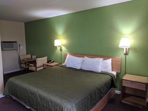 una camera d'albergo con letto e parete verde di Benton Inn a Benton
