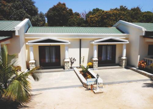 a small white house with a green roof at SAARA HOTEL in Mahajanga
