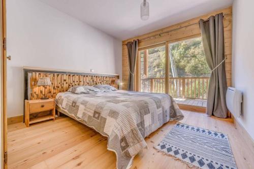 een slaapkamer met een bed en een groot raam bij Le Reclard - Les Balcons Etoilés in Champagny-en-Vanoise