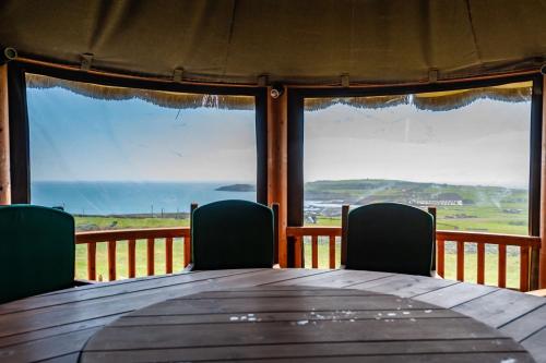 a table with two chairs and a view of the ocean at Ocean View,Kinsale, Hosted by Exquisite holiday homes, sleeps 22 in Kinsale