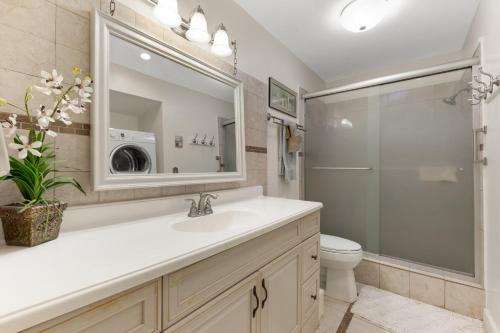 W łazience znajduje się umywalka, toaleta i lustro. w obiekcie Madeira Beach Condo w St Pete Beach