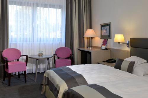 a hotel room with a bed and a table and chairs at Hotel Spiegel in Cologne