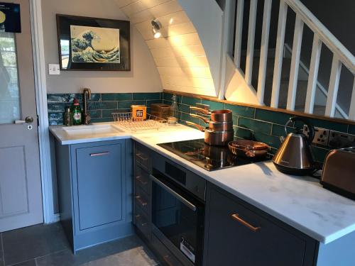 a kitchen with a stove top oven next to a staircase at Fistral Court in Newquay