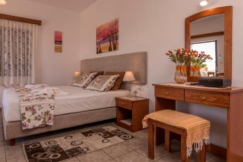 a bedroom with a bed and a desk and a mirror at Roula Apartments in Palaiochora