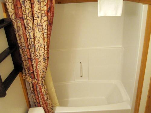 a bath tub in a bathroom with a shower curtain at Cornerstone Lodge by Park Vacation Management in Fernie