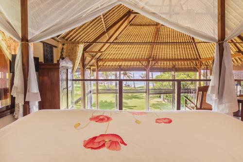 ein Zimmer mit einem Bett mit Blumen darauf in der Unterkunft Citakara Sari Villas in Candidasa