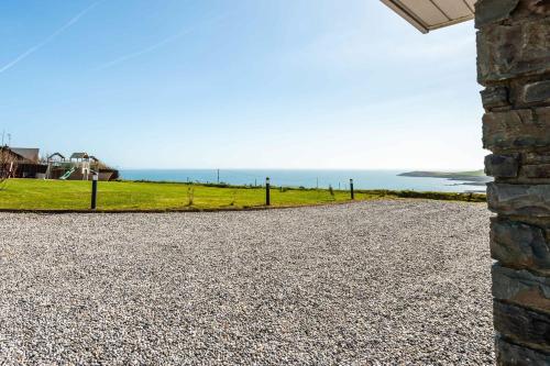 a gravel driveway with the ocean in the background at Ocean View,Kinsale, Hosted by Exquisite holiday homes, sleeps 22 in Kinsale