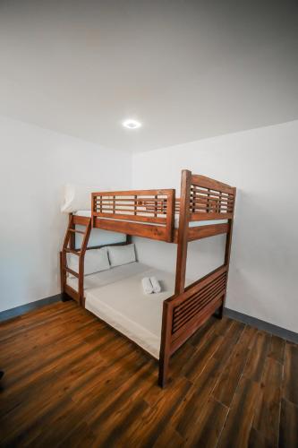 two bunk beds in a room with a wooden floor at Bataan White Corals Beach Resort in Morong
