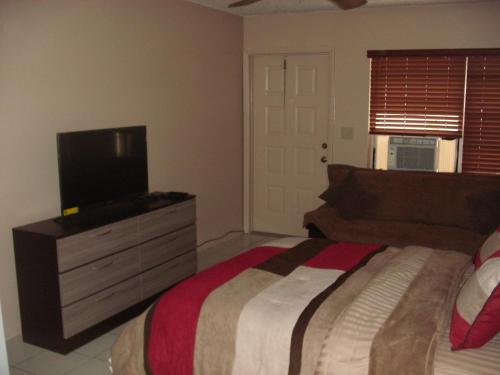 a bedroom with a bed and a flat screen tv at Newly Furnished Large, Clean, Quiet Private Unit in Fort Lauderdale