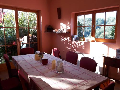 a dining room with a table and chairs and windows at Casa Re - B&B e Vino a Montabone in Montabone