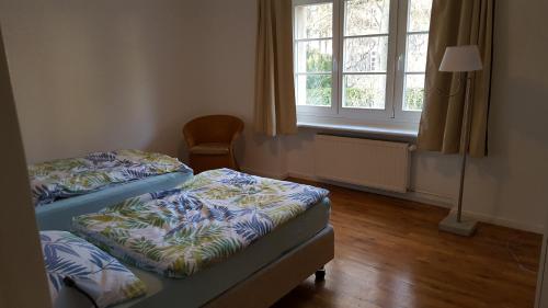 two beds in a room with a window at Beautiful House in Zehlendorf in Berlin