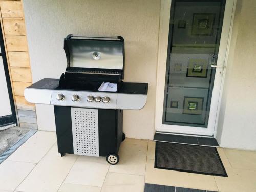 a barbecue grill sitting in front of a door at Gîte de la Vallée in Dambach