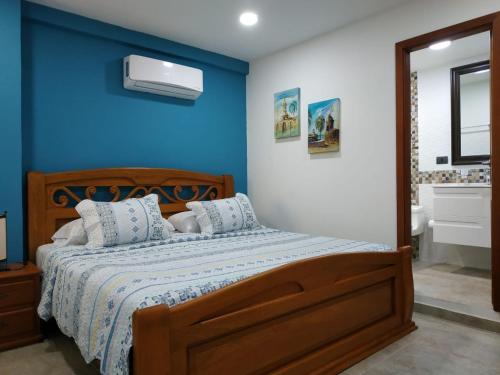 - une chambre dotée d'un lit avec un mur bleu dans l'établissement APARTAMENTOS DECOR, à Carthagène des Indes
