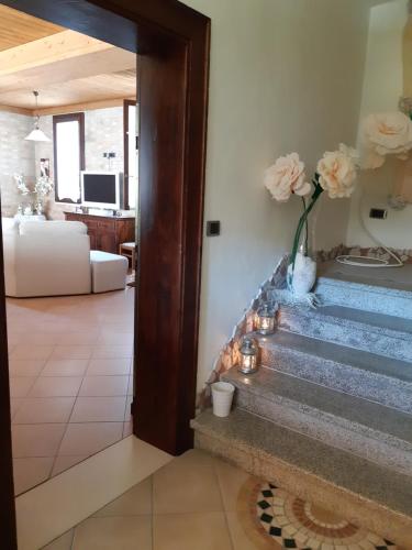 una sala de estar con una escalera con flores en un jarrón en Il Focolare B&B, en Casa Ottani