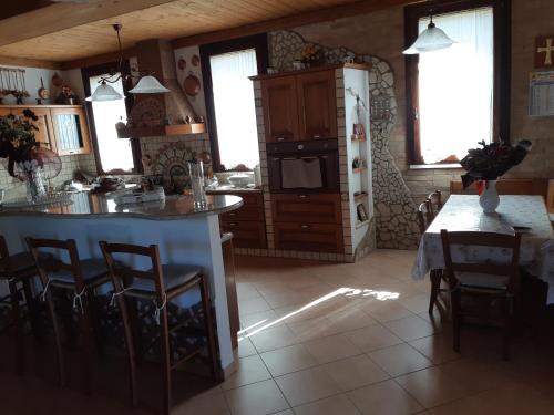 a kitchen with a counter and a refrigerator and a table at Il Focolare B&B in Casa Ottani