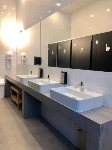 a bathroom with three sinks in a public restroom at HOSTEL ALAMEDA EXCLUSIVE HOUSE in Faro