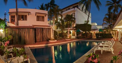 una casa con piscina frente a una casa en Hotel La Pergola, en Manzanillo