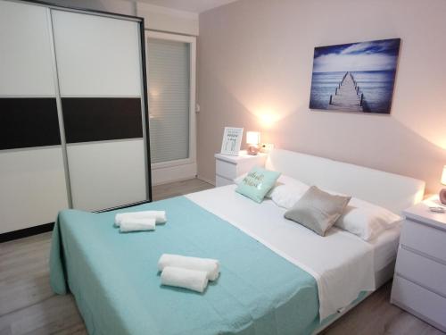 1 dormitorio con 1 cama grande y toallas. en Aquamarine apartment en Split