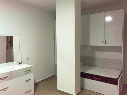 mała sypialnia z łóżkiem i lustrem w obiekcie Residenca Juli we Wlorze