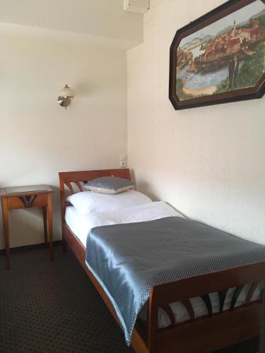 a bedroom with a bed and a painting on the wall at Zagroda Kołodzieja in Zgorzelec