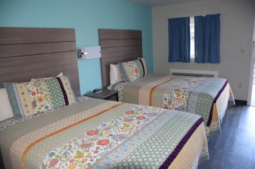 A bed or beds in a room at White Rose Motel - Hershey