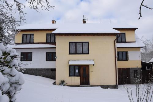 a house with snow on top of it at Apartmány Kvasejovice in Sušetice