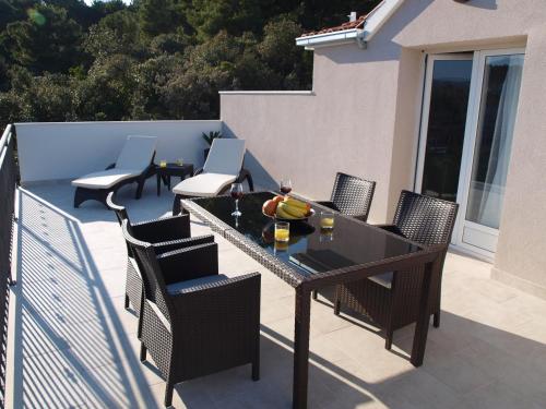 a patio with a table and chairs on a balcony at Holiday Hvar in Vrbanj