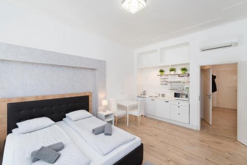 ブダペストにあるAstoria Flats 1の白いベッドルーム(ベッド2台付)、キッチンが備わります。