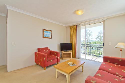 a living room with a couch and a table and a television at Palazzo Colonnades in Gold Coast