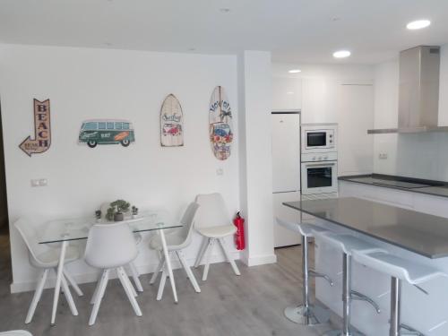 a kitchen with white walls and white stools at Beach House in Puerto de Mazarrón