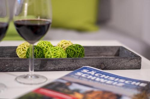 a glass of wine sitting next to a tray of pasta at Apartmenthaus Luise in Bad Schandau