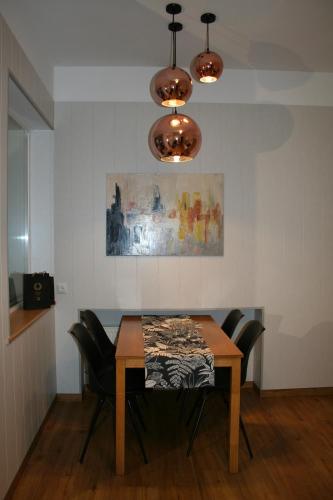 a dining room table with black chairs and a painting at Sadama street Villa in Pärnu