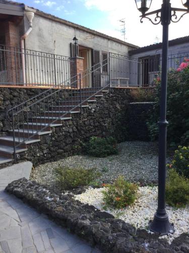 um edifício de pedra com uma escada e uma luz de rua em Villa La Scogliera em Acireale