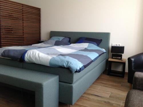 een slaapkamer met een bed, een stoel en een tafel bij Studio aan 't Strand Bed by the Sea Adults only in Westkapelle